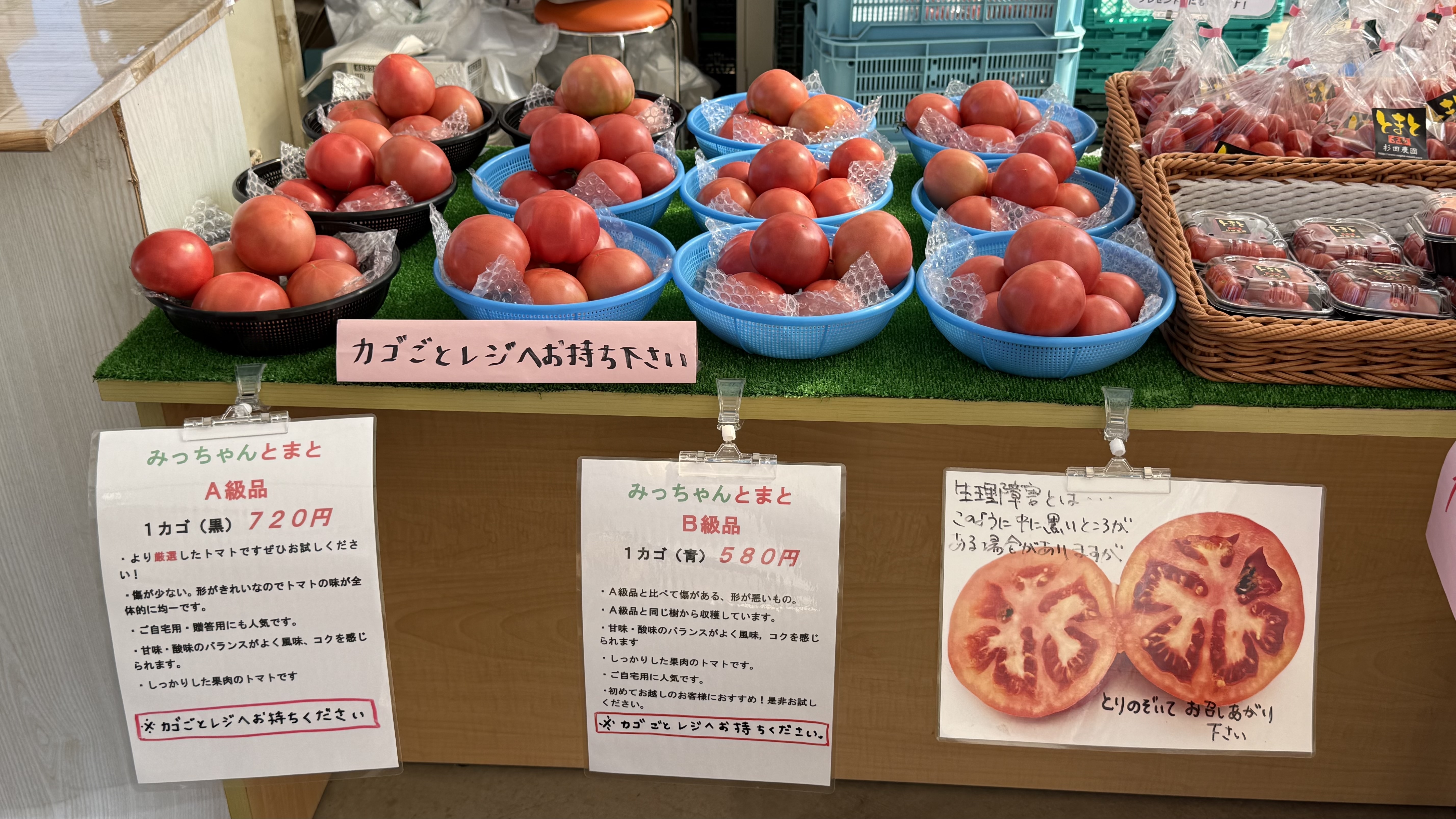 京都杉田農園の直売所で、大玉トマトとミニトマトがざるに盛られて並ぶ販売コーナー